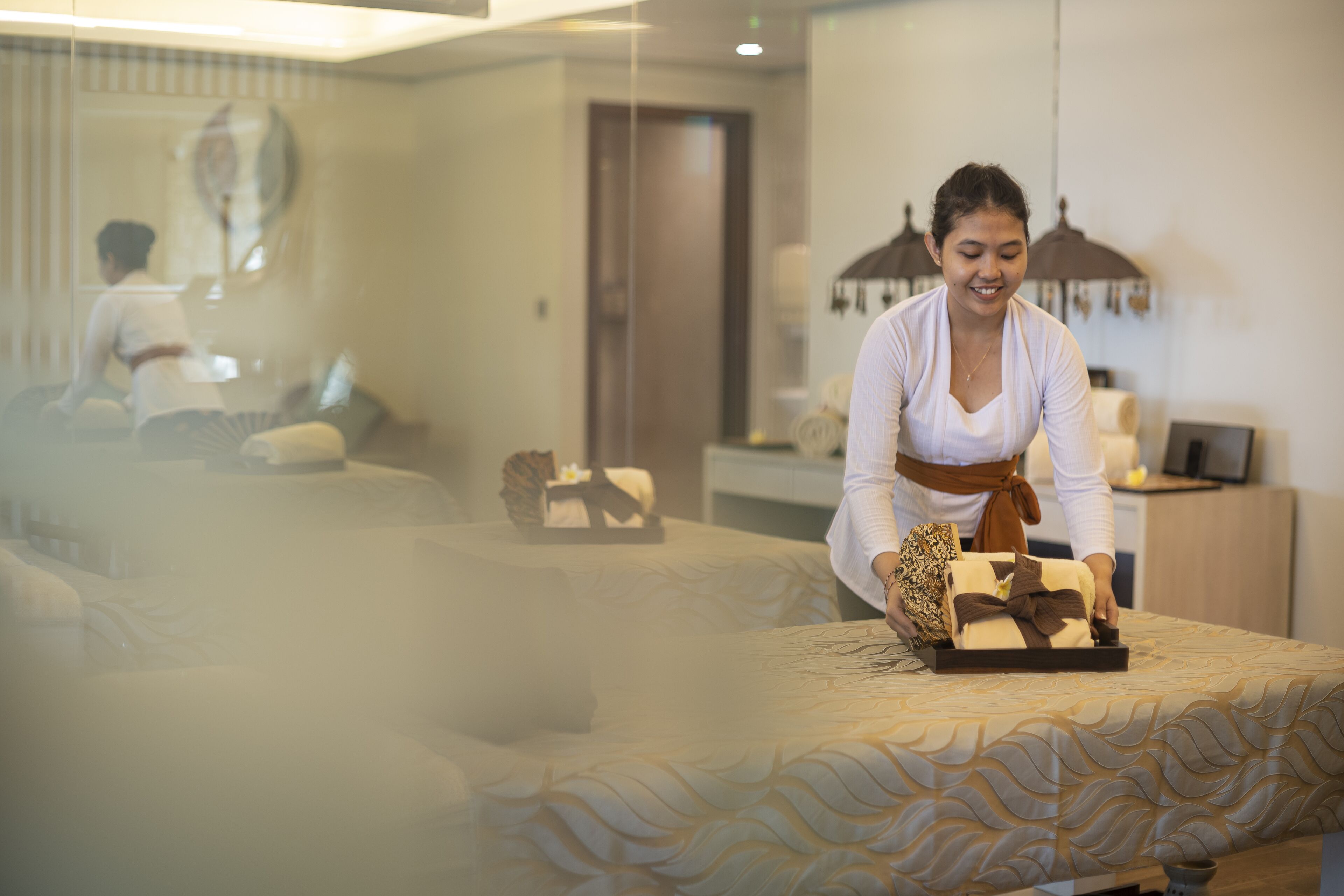 A hotel room with a bed, a massage table, and a mirror.