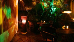 Un espacio interior con mesas, sillas, una escalera y una zona de bar.