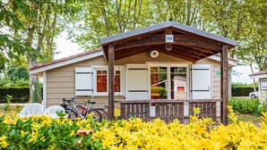 A small, single-story building with a porch, a bicycle parked outside, and a sign indicating the number 46.