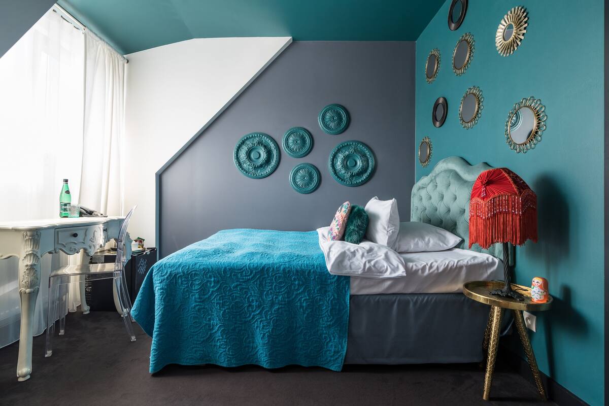 Un dormitorio con una cama, un escritorio y una silla. Hay platos decorativos en la pared.