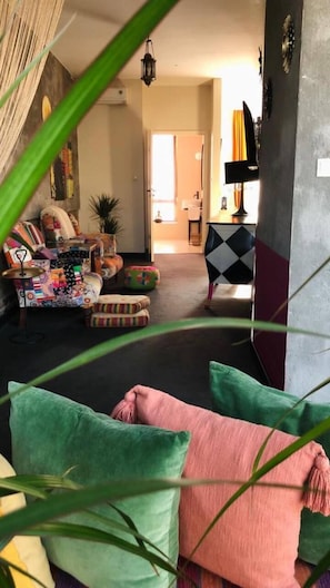 Una sala de estar acogedora con un sofá, cojines coloridos y una mesa de centro.