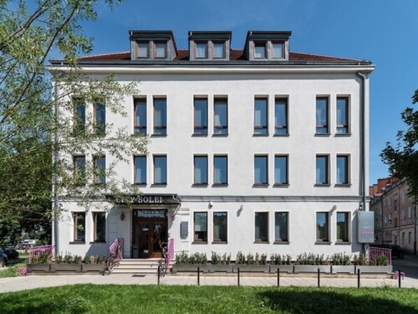 Un edificio blanco con múltiples ventanas y un letrero que dice "City Solei".