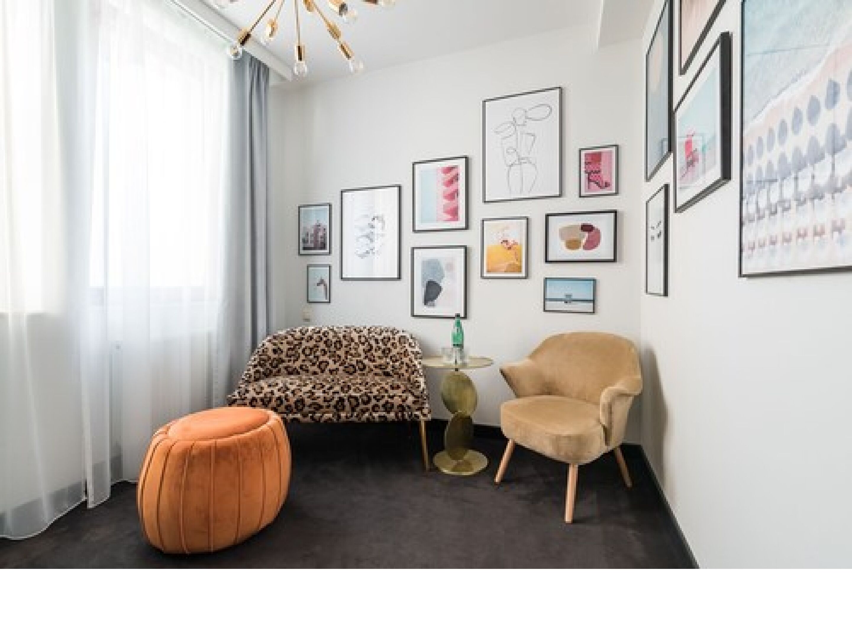 A modern living room with a sofa, armchair, ottoman, and a coffee table.