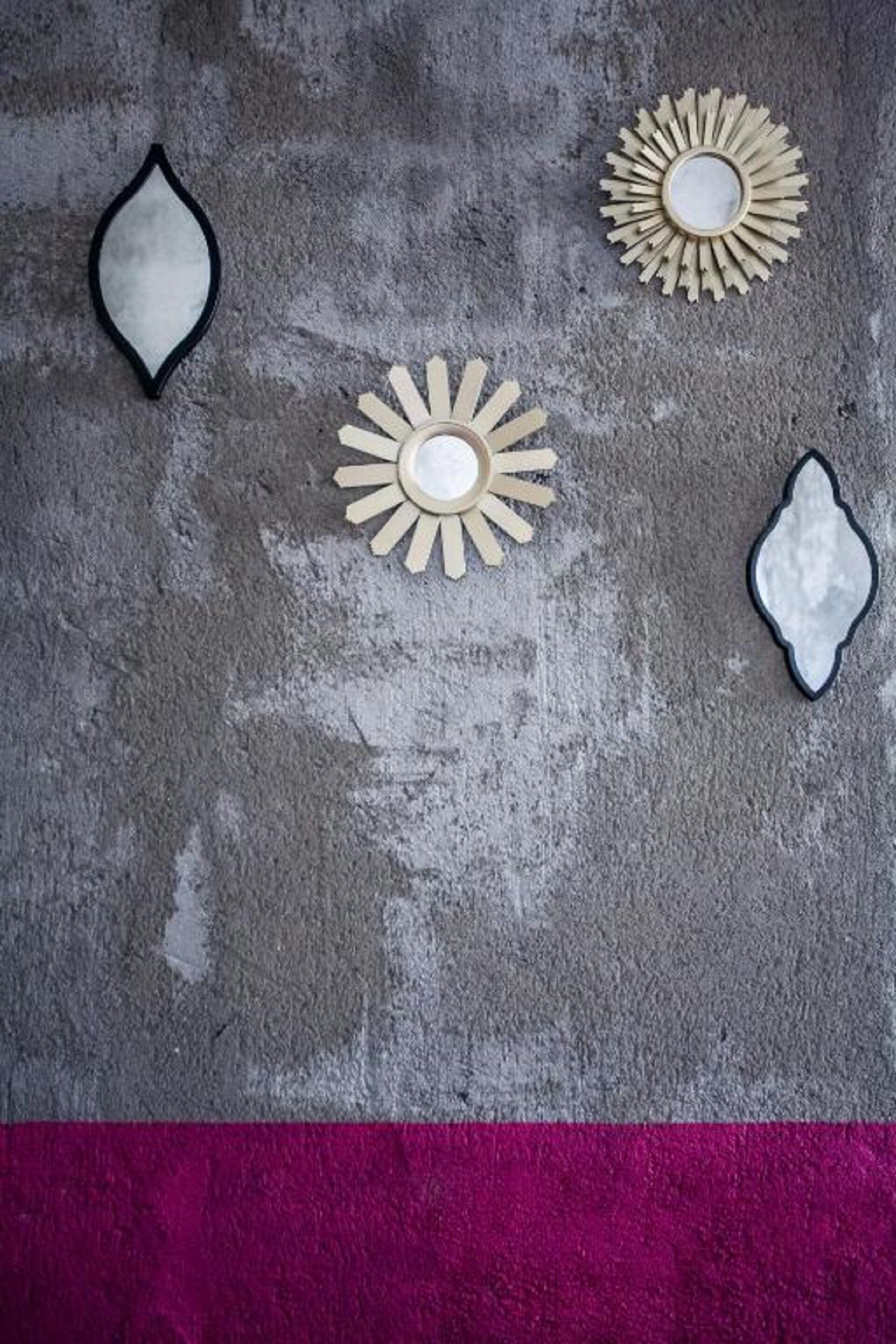 Three wall-mounted decorative items on a textured gray wall.