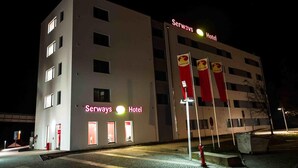 A modern hotel with a flat facade, multiple windows, and a prominent sign reading "Serways Hotel". - Serways Hotel Nürnberg Feucht Ost (Schwarzenbruck)