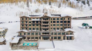 A multi-story hotel with a pool area and ski slope access.