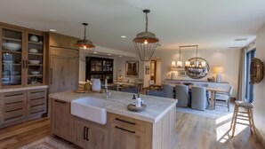 Una cocina amplia con armarios de madera, una isla grande e iluminación colgante.