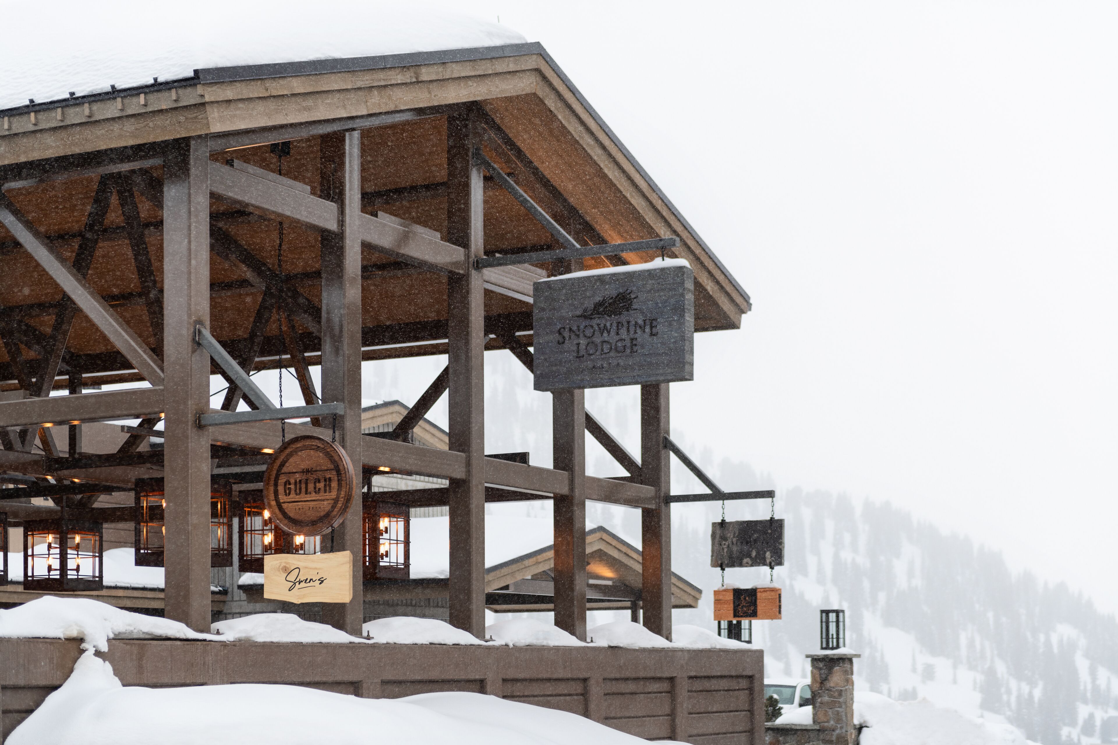 A snow-covered lodge with a sign reading "Snowpine Lodge".