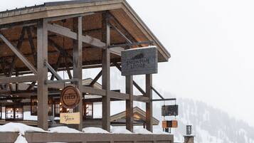 A snow-covered lodge with a sign reading "Snowpine Lodge".