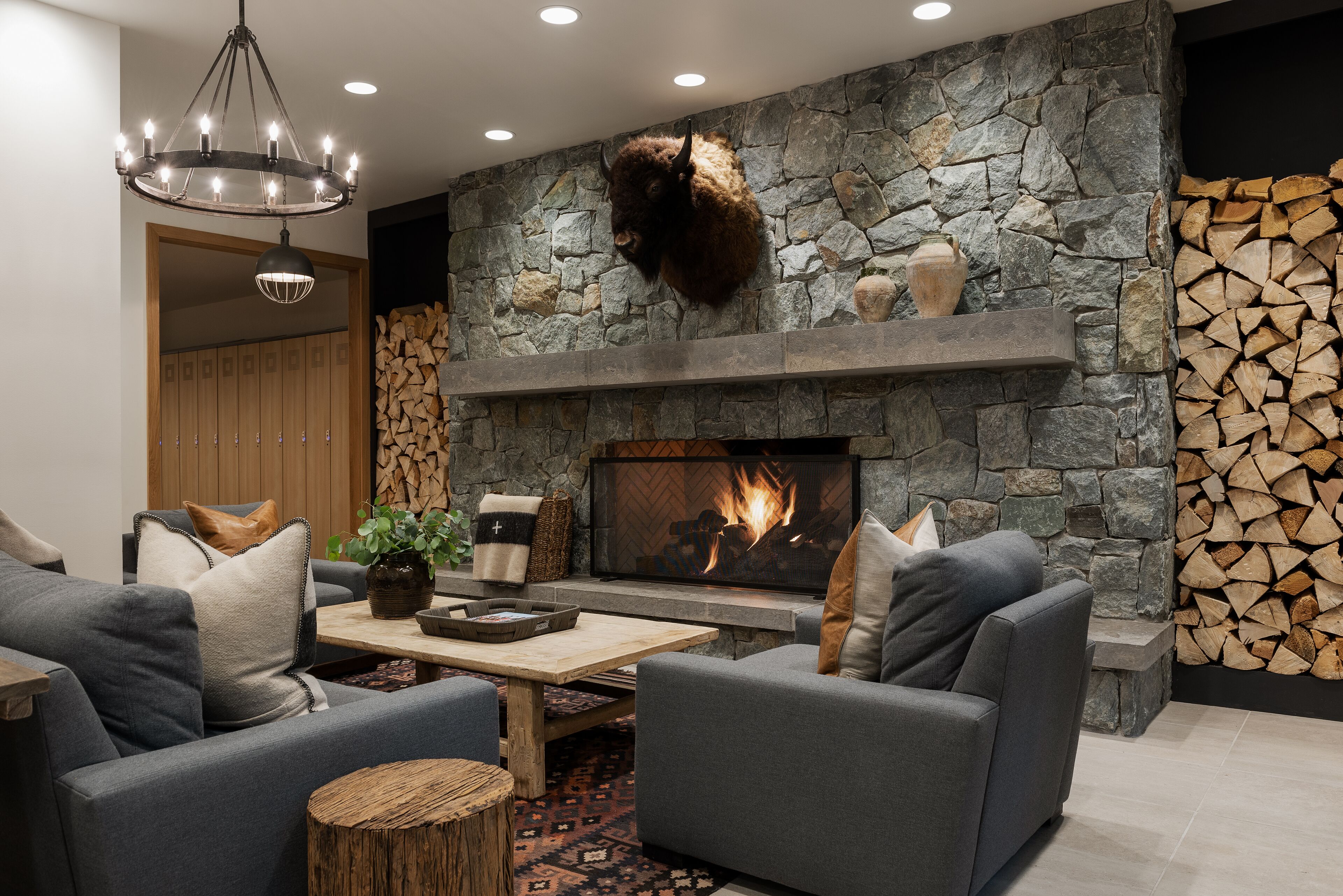 A modern living room with a stone fireplace, sofas, and a coffee table.