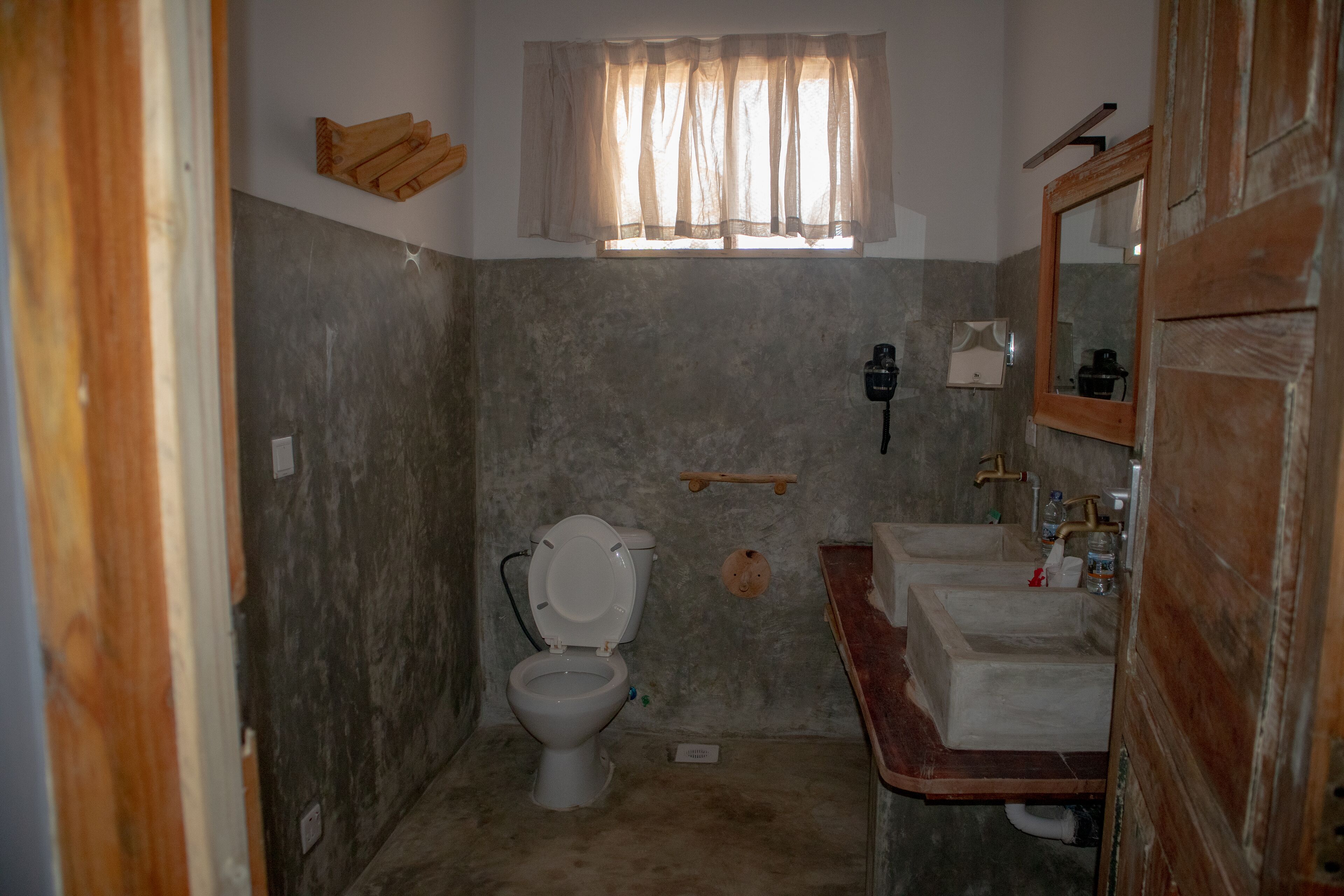 A small, compact bathroom with a toilet, a sink, and a mirror.