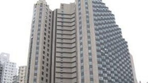 Un edificio alto con una entrada curva y varios pisos.
