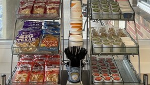 A bakery display with various baked goods and packaged snacks.