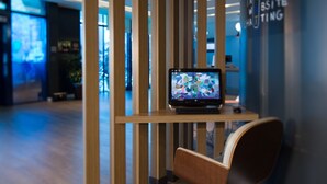 A modern office space with a laptop on a desk, a wooden partition, and a wall with text. - ibis Passo Fundo Centro Hotel (Passo Fundo)
