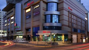 A hotel with multiple floors, a prominent 'ibis HOTEL' sign, and various business signs including 'Burger King' and 'arcoiris'. - ibis Passo Fundo Centro Hotel (Passo Fundo)