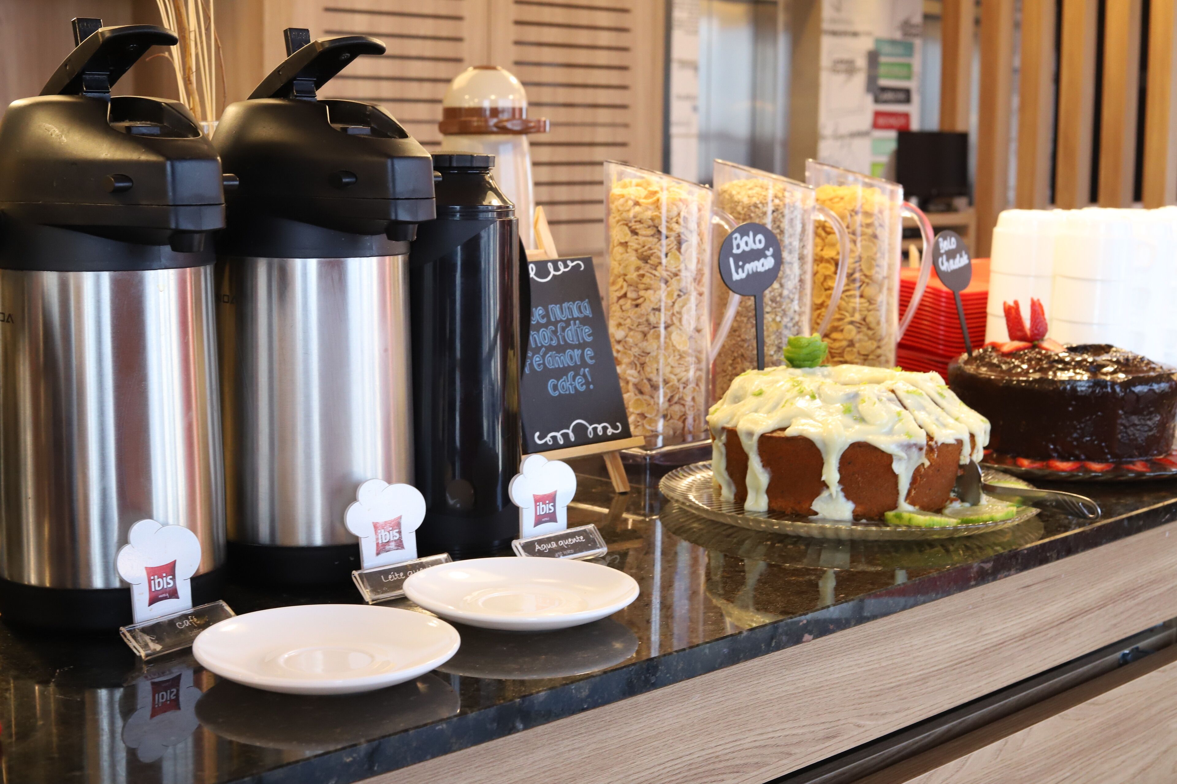 A coffee station with various coffee makers and a cake on display.