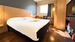 A hotel room with a large bed, a desk, a chair, a TV, and a window with curtains. - ibis Passo Fundo Centro Hotel (Passo Fundo)