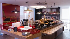 A buffet setup with various food items, serving trays, and baskets. - ibis Passo Fundo Centro Hotel (Passo Fundo)
