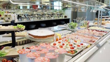 A buffet with various food items, including meats, cheeses, and salads, displayed in a glass case.