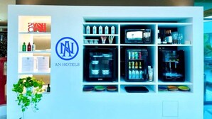 A hotel reception area with a reception desk, a digital display, and a variety of amenities including toiletries and beverages. - AN HOTEL MILANO MELEGNANO (Carpiano)