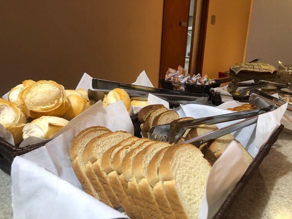 Un buffet proposant une variété de pains et de viennoiseries, notamment des tranches de pain et des croissants, présentés sur des plateaux.