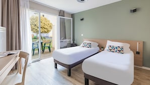 A hotel room with two beds, a desk, and a sliding glass door leading to an outdoor area. - Appart'City Confort Niort Centre (Niort)