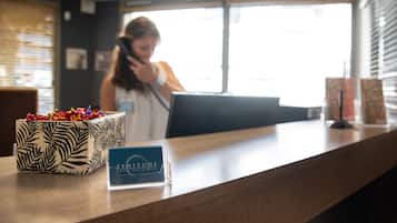 A hotel reception desk with a sign for 'Zenitude Hotel Residences'.
