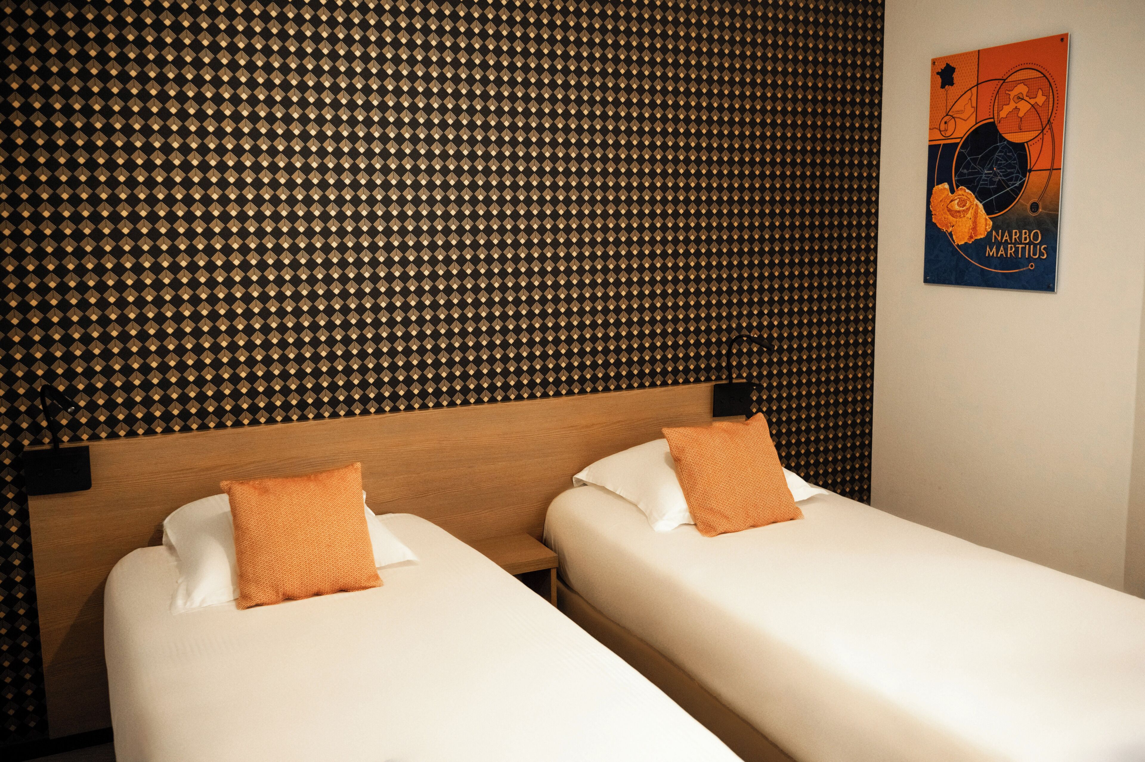 A hotel room with two single beds, a patterned wall, and a poster on the wall.