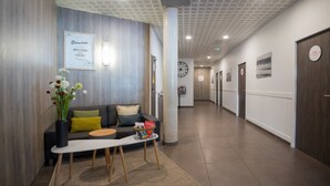Una moderna zona de recepción con un sofá, una mesa de centro y un jarrón con flores.
