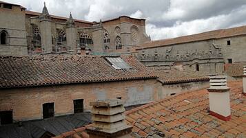 A historic building with a tiled roof and stone walls, featuring arched windows and decorative elements.