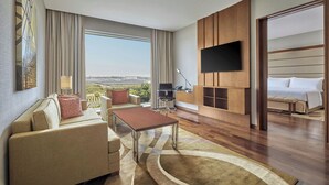 Una habitación de hotel moderna con sofá, mesa de centro y televisor de pantalla plana montado en la pared.