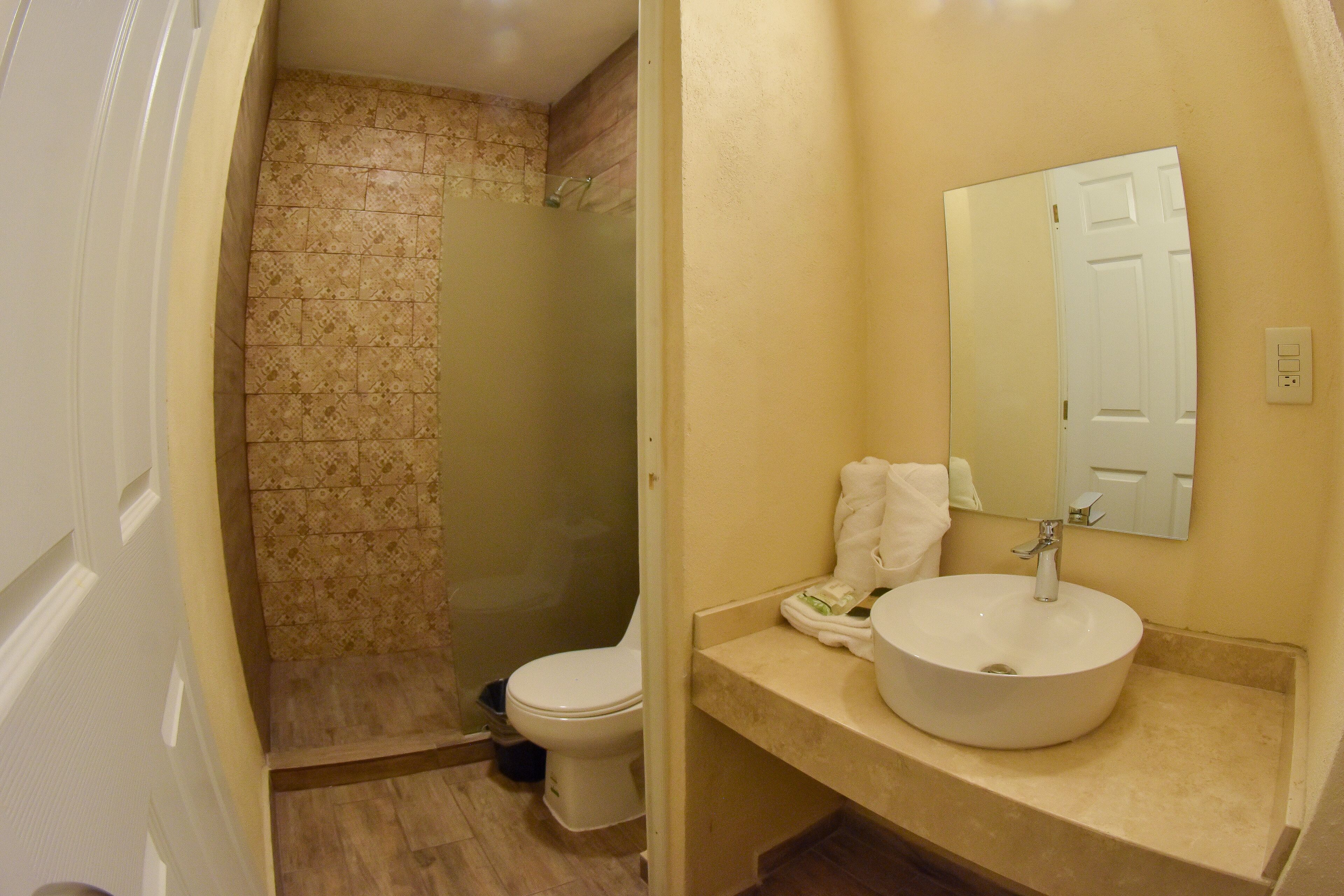 Een badkamer met toilet, wastafel en douche.