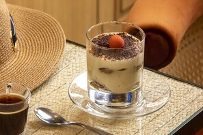 A dessert in a glass on a woven placemat, a spoon, and a straw in a cup. - Hôtel Sleeping Belle - Gare de Lyon Bastille (Paris)