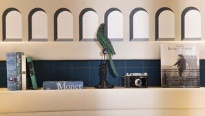 A bookshelf with books, a camera, and a decorative bird. - Hôtel Sleeping Belle - Gare de Lyon Bastille (Paris)
