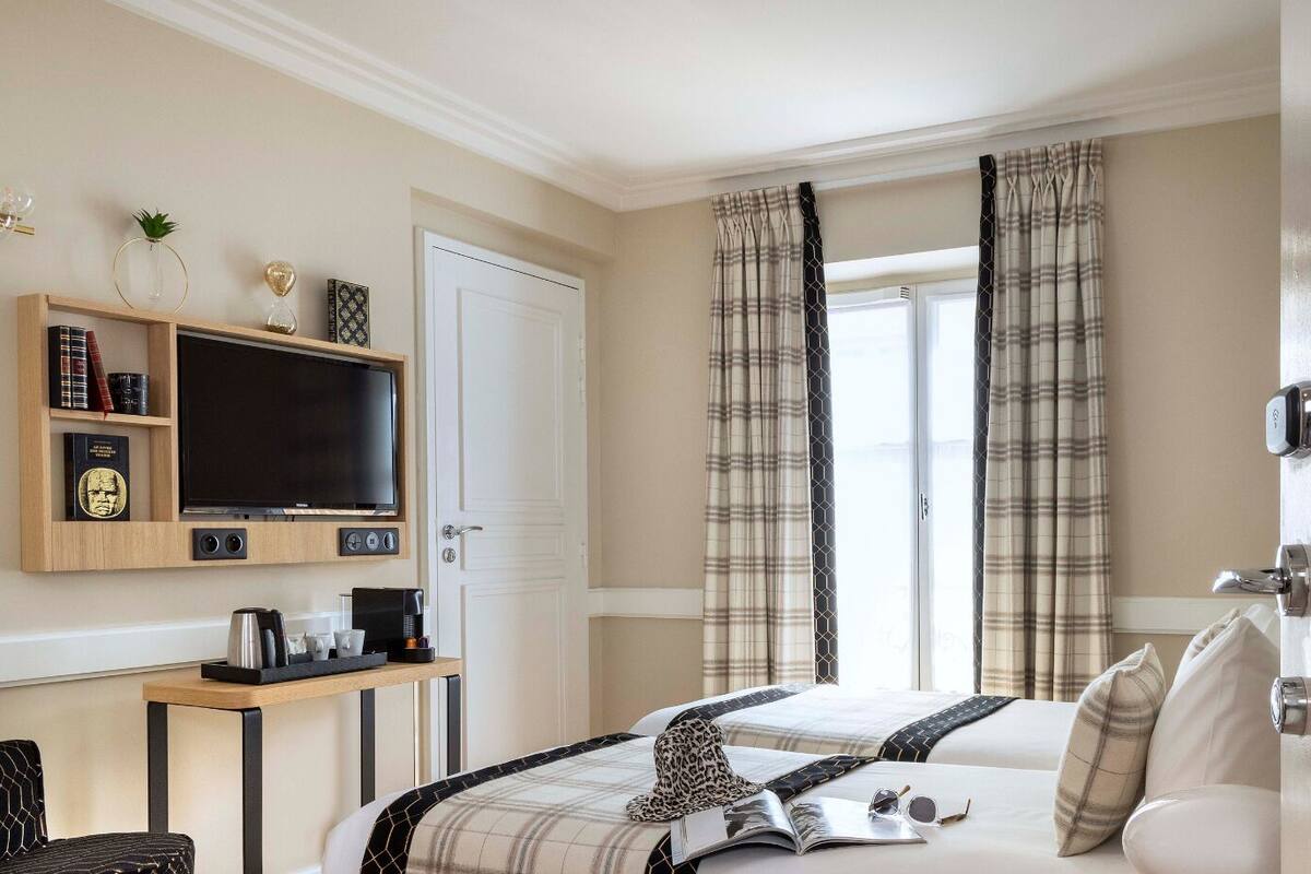 Een hotelkamer met een bed, een televisie, een koffiezetapparaat, een bureau en een deur met het nummer 504.