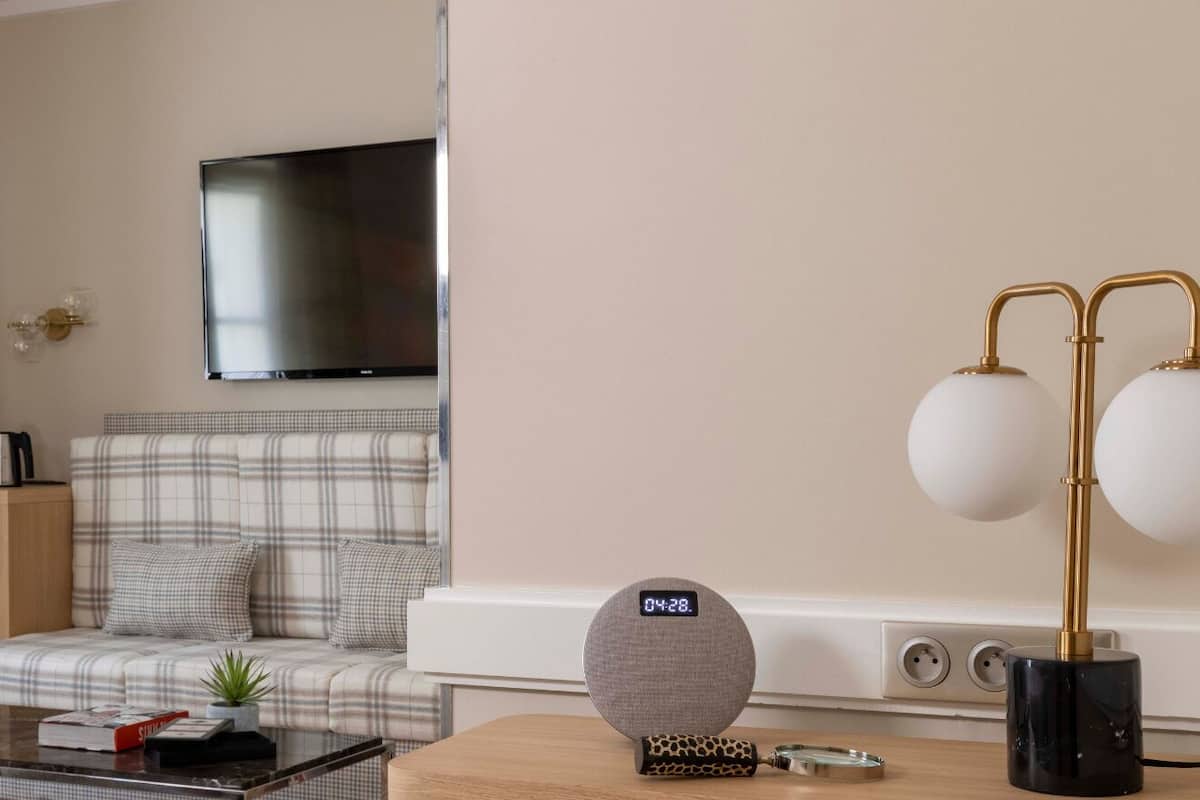 Een moderne woonkamer met een bank, een salontafel, een televisie en een lamp.