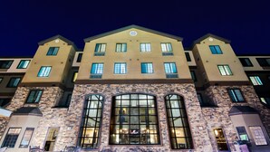 A multi-story hotel with a stone facade, large arched windows, and multiple balconies. - Staybridge Suites Grand Forks by IHG (Grand Forks)