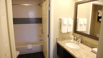 A bathroom with a bathtub, a sink, and a mirror.