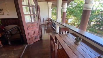 Interior de madera con un amplio ventanal, bancos de madera y vistas al exterior con vegetación.