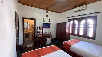 A hotel room with two beds, a desk, a television, and a wardrobe.