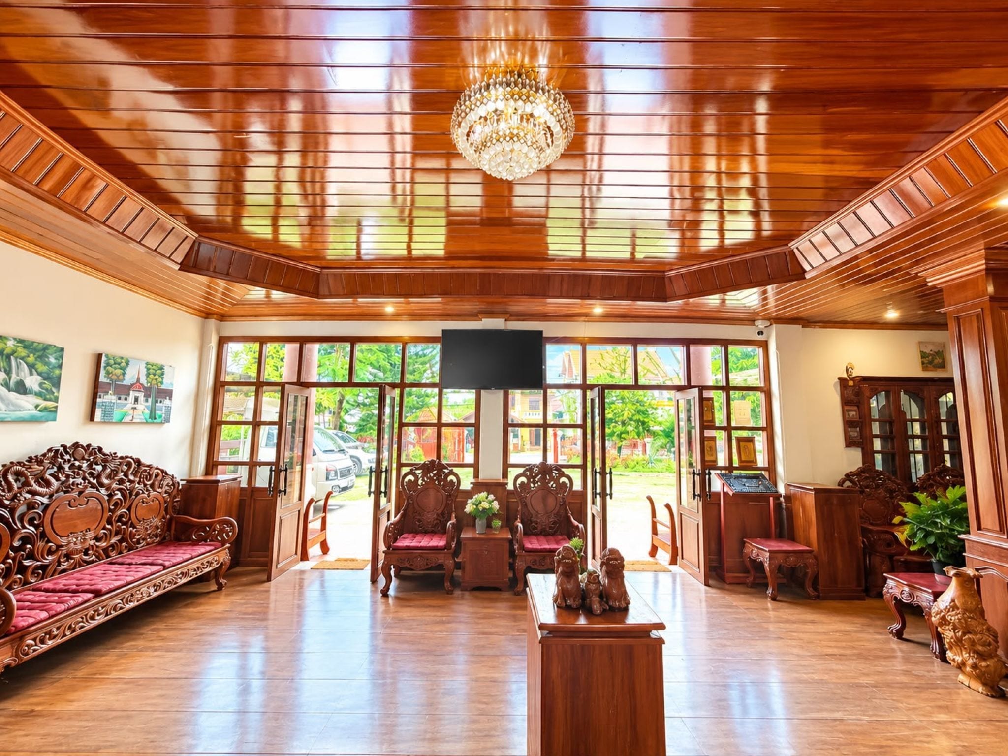 A spacious room with a wooden ceiling, large windows, and traditional furniture.
