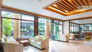 A spacious lobby with modern furniture, large windows, and a wooden ceiling. - V Residence Chiangmai Hotel (Chiang Mai)