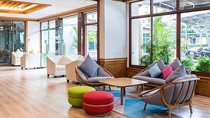 A spacious lobby with modern furniture, large windows, and a view of the outdoors. - V Residence Chiangmai Hotel (Chiang Mai)