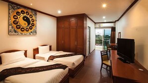 A hotel room with two beds, a television, a wooden wardrobe, and a large artwork on the wall. - V Residence Chiangmai Hotel (Chiang Mai)