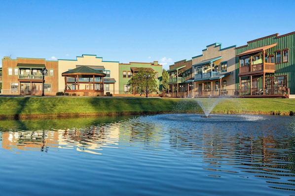 A row of multi-story buildings with a fountain in the foreground.