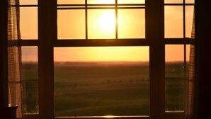 A room with a large window divided into six panes, a table, and a chair. - HYATT house Minot (Minot)