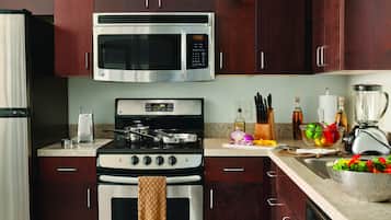 A kitchen with a microwave, stove, oven, and various kitchen utensils.
