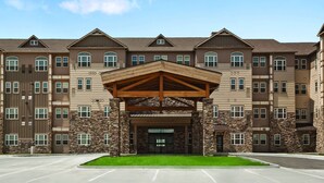 A multi-story hotel with a central entrance, stone facade, and multiple windows. - HYATT house Minot (Minot)
