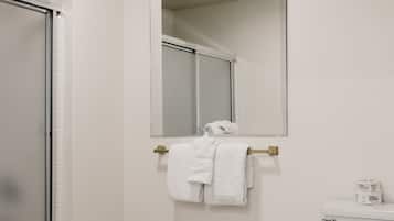 Un baño con inodoro, espejo y toallero.