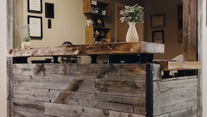 Una recepción con un diseño rústico de madera, una planta en maceta y certificados enmarcados en la pared.